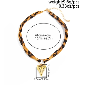 Detail showing leopard print fabric strap and large golden heart pendant measurement
