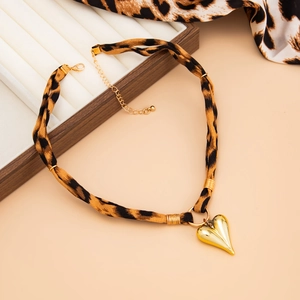 Detail of leopard print fabric choker with a gold heart pendant and adjustable lobster clasp
