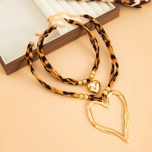 Double-layered leopard print necklace with chunky gold heart pendants and fabric links
