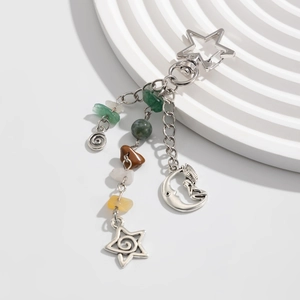 Detail of silver celestial keychain featuring star moon charms and colorful raw stone beads