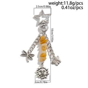 Detail of silver star keychain with dragonfly butterfly and sun charms in a macro view