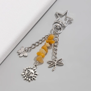Detail of vintage silver keychain with celestial sun charms and yellow raw stones