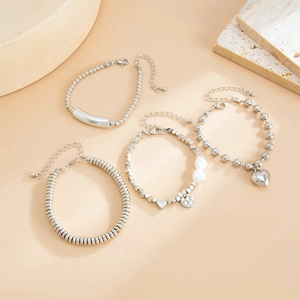 Detail of four-piece silver beaded bracelet set with heart pendants and pearls