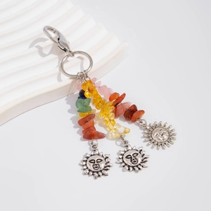 Detail of bohemian sun pendant keychain with colorful natural crushed stones and alloy charms