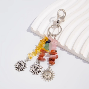 Detail of bohemian sun keychain with colorful raw stones and silver charms