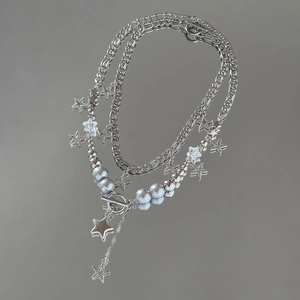 Detailed close-up of Baroque multi-layer star pendant necklace with pearls and OT buckle