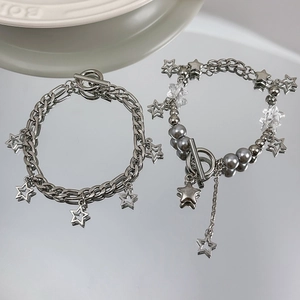 Detailed shot of silver star charm bracelets with pearls and OT toggle clasps on a mirror