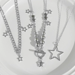 Macro shot of silver baroque star pendant necklaces with OT buckle and bead chain details