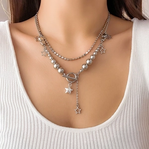 Close-up of layered silver star pendant necklace with OT toggle clasp on a female model