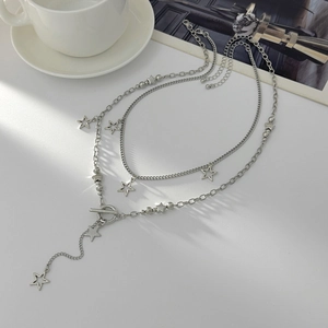 Star pendant necklace with toggle clasp and layered chains on minimalist background
