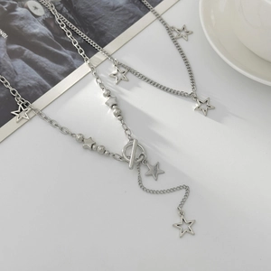 Detail of silver star pendant necklace set with OT clasp and layered metal chains