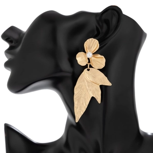 Detail of gold floral tassel earring with white pearl on a black mannequin display
