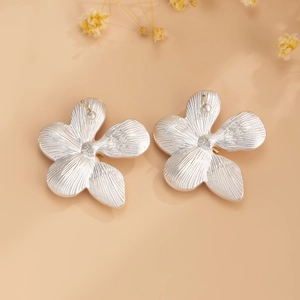 Detailed close-up of matte silver ginkgo flower earrings with vein texture on petals