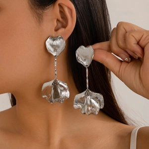 Detail view of silver ginkgo leaf flower earrings with brushed texture on model