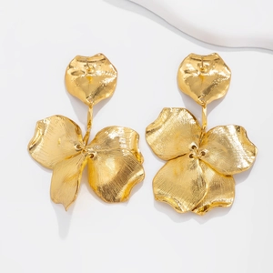 Detail of golden double-layer flower earrings with textured matte finish and tassel design