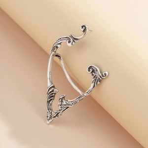 Detail of vintage silver ear cuff showing intricate leaf engravings and gothic texture