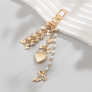 Détail d'un porte-clés médaillon doré avec perles, nœuds et gravure I Love You florale