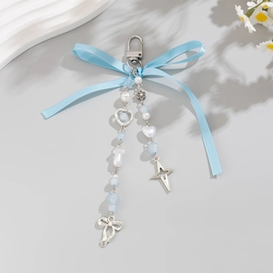 Détail d'un porte-clés à nœud bleu clair avec pendentifs coeur et étoile en argent