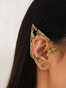 Detail of vintage gold rose vine ear cuff with intricate floral and leaf texture