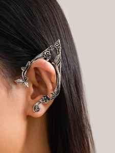 Close-up of vintage silver elf ear cuff with intricate rose and leaf vine design