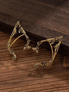 Detailed view of vintage gold elf ear cuffs with rose petals and leaf textures