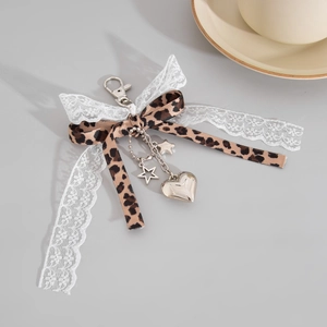 Vue détaillée des pendentifs cœur et étoile sur un porte-clés ruban dentelle léopard