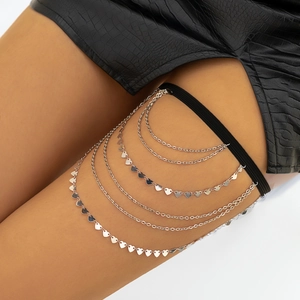 Detail of multi-layer silver thigh chain with heart sequins on black elastic band