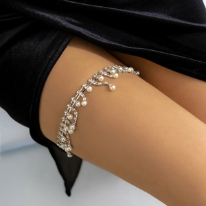 Detail of bohemian silver thigh chain featuring layered rhinestones and faux pearls