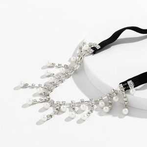 Detail of bohemian thigh chain with silver rhinestones and white pearl fringe tassels