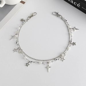 Detail van dubbele zilveren ketting met imitatieparels, sterhangers en metalen karabijnsloten