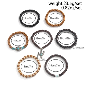 Detail of seven Bohemian style wood bead bracelets featuring a silver cactus charm