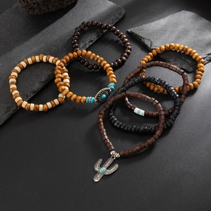 Detail of bohemian wooden bead bracelet set with silver cactus and sun metal pendants