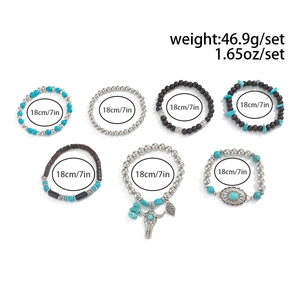 Detail of 7-piece bohemian bracelet set featuring turquoise, wood beads and metal charms