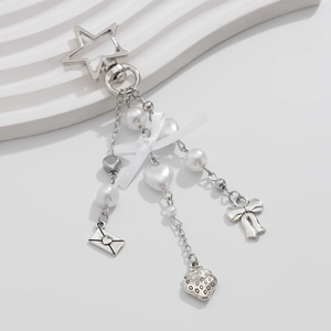 Dettaglio del portachiavi argento con perle bianche e un fiocco di nastro in raso bianco