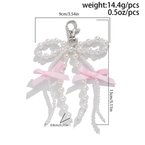 Dettaglio del ciondolo con perle e fiocco che mostra altezza 13cm e peso di 14,4g