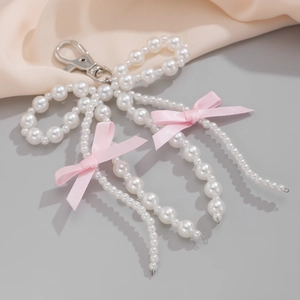 Dettaglio del fiocco di perle con nastri di seta rosa e chiusura a moschettone