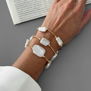 Baroque irregular pearl bracelets set with gold beads on model with white shirt