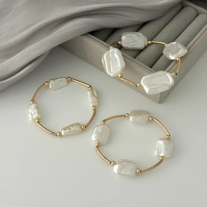 Baroque irregular pearl bracelet with gold metal tubes in a minimalist layered design
