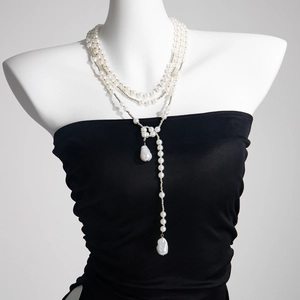 Détail d'une broche chaîne multi-rangs en perles avec perles baroques sur un mannequin