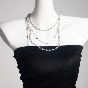 Collier multicouche avec perles et pendentifs étoiles argentés sur un support de mode