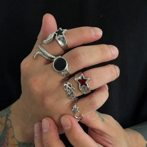 Detail shot of five vintage punk rings featuring black star and snake motifs for men