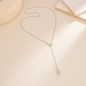 Close-up of silver Y-shaped long tassel necklace with a delicate water drop pendant