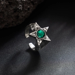 Dettaglio dell'anello a stella vintage con gemma verde e finitura argento invecchiato
