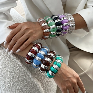 Chunky colorful resin bracelet with silver metal spacers on a white suit background