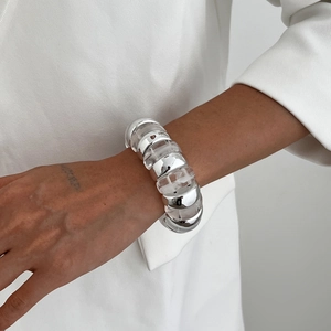 Modern chunky silver metal and clear resin link bracelet on woman's wrist