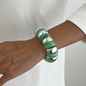 Detail of green resin and polished silver metal links on a wide elastic bracelet