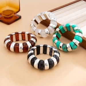 Close-up of chunky resin and silver bead stretch bracelets in amber and marble tones