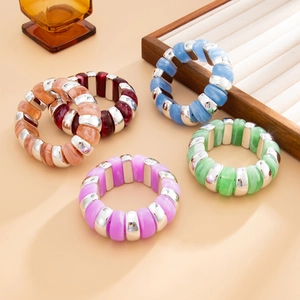 Detailed view of colorful resin bracelets with silver spacers on a display tray