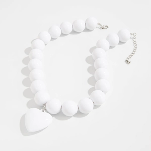 Detalle del collar de perlas blancas con colgante de corazón 3D y cierre de langosta plateado