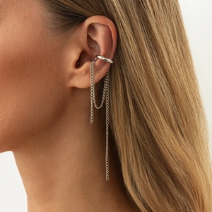 Close-up of silver ear cuff with asymmetric long tassels and polished metal chain design